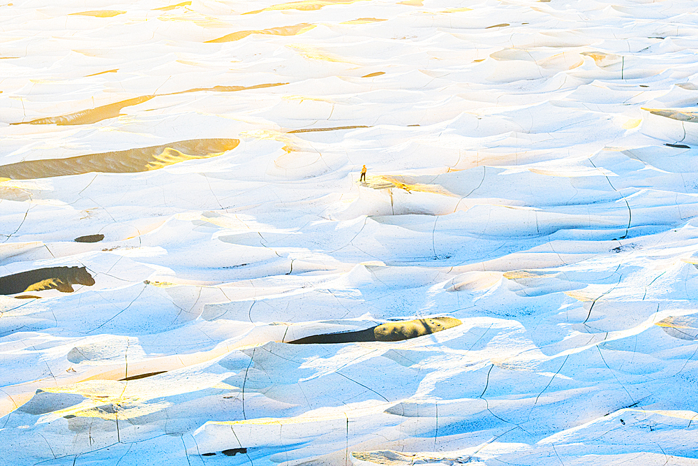 One person standing in the pumice landscape of Campo de Piedra Pomez at dawn, aerial view, El Penon, Catamarca, Argentina
