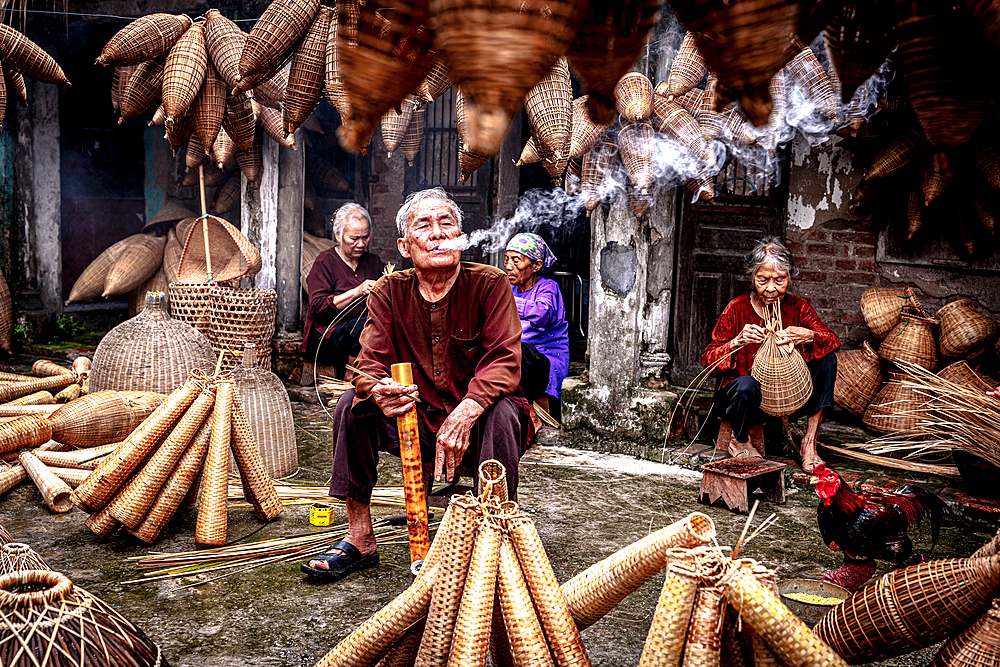 Man smoking while making bamboo fish traps, Hanoi, Vietnam. (MR)