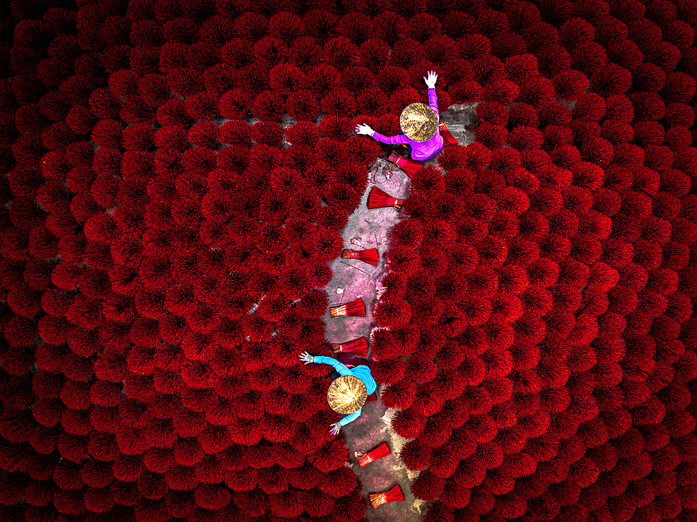 Drone view of local workers drying red incense sticks, Hanoi, Vietnam