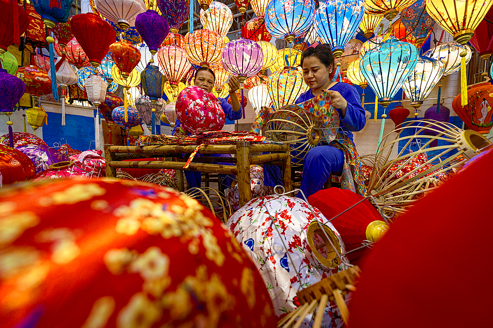 Woman making the traditional colorful lanterns, Hoi An, Quang Nam Province, Vietnam. (MR)