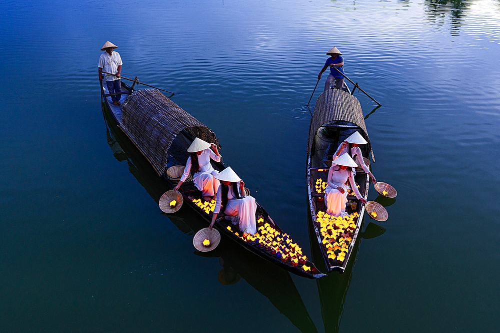 Women releasing floating lanterns into Nhu Y River, Hue, Central Vietnam. (MR)