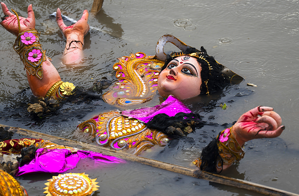 Hindu devotees immerse a clay idol of Goddess Durga into the Brahmaputra River on the concluding day of the Durga Puja festival, in Guwahati, Assam, India on 2 October 2025.