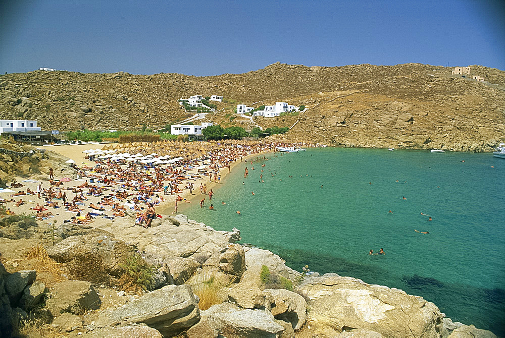 Tourists on the Super Paradise beach with small houses in the background, on Mykonos, Cyclades Islands, Greek Islands, Greece, Europe