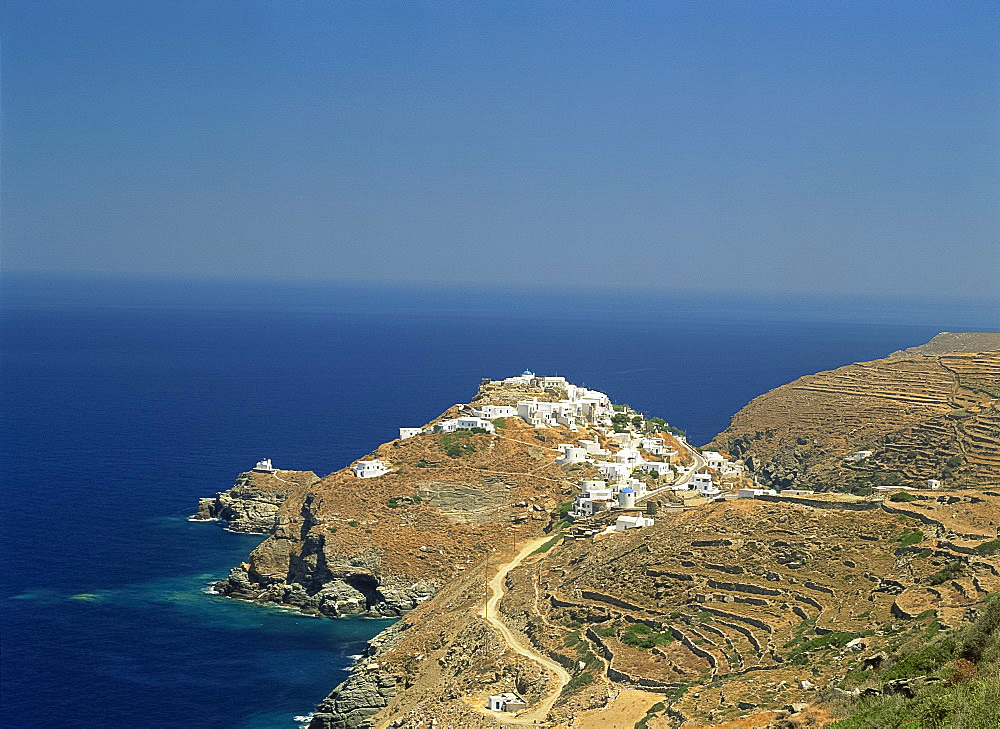 Coastline with The Kastro village on hill beyond terraces on Sifnos, Cyclades, Greek Islands, Greece, Europe