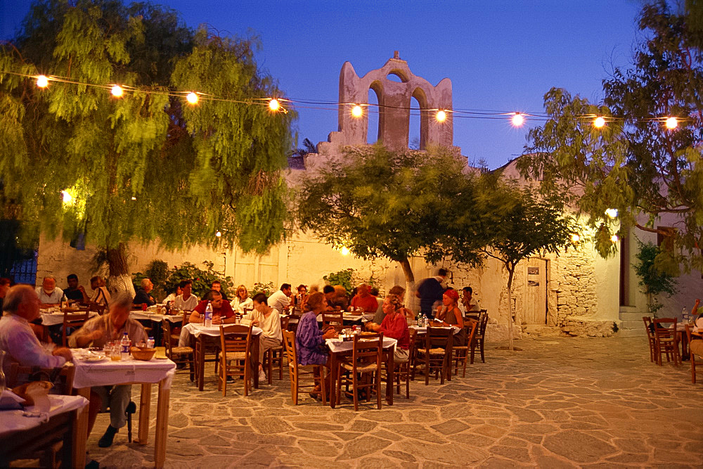 Tourists at open air taverna in the evening on Folegandros, Cyclades Islands, Greek Islands, Greece, Europe