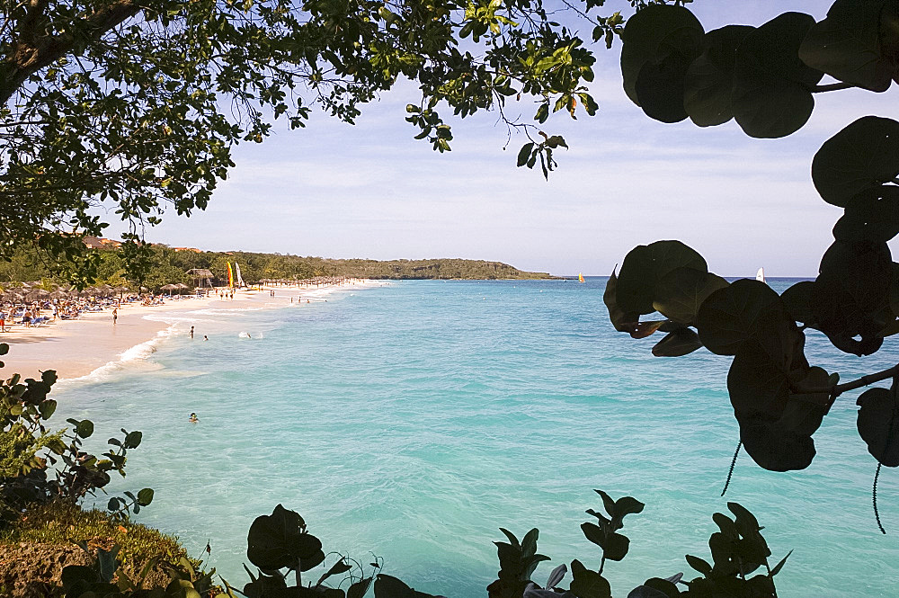 A view through trees to the Playa Esmeralda, Carretera Guardalavaca, Cuba, West Indies, Central America