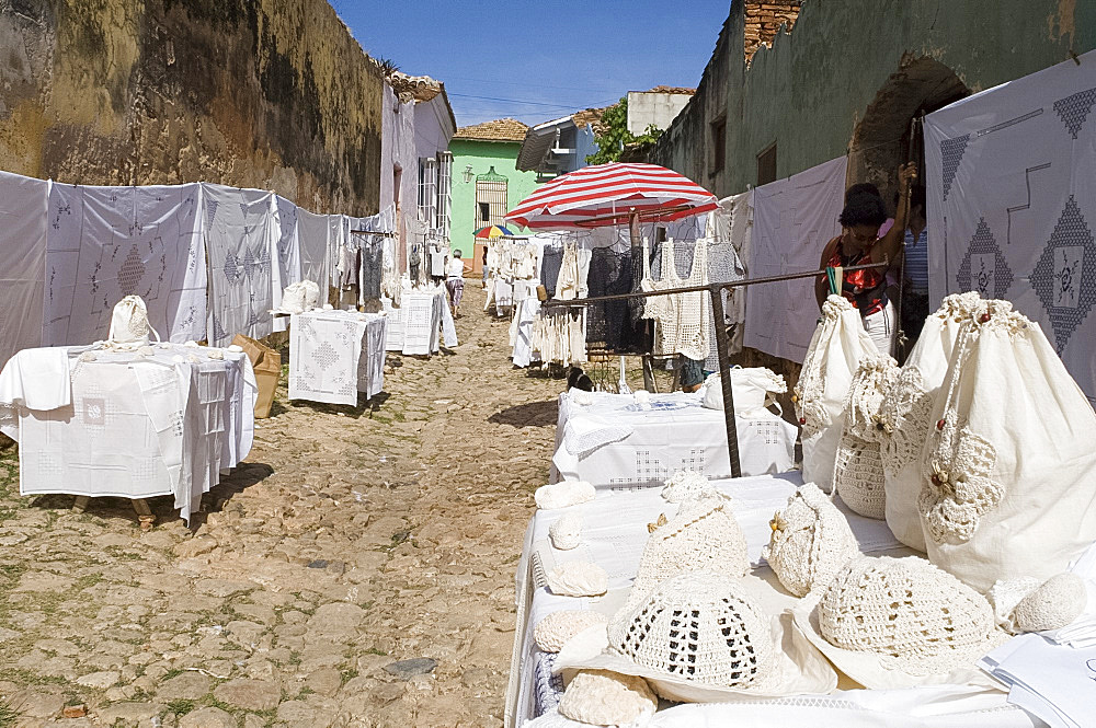 Crocheted and embroidered linens for sale on an old cobbled street in Trinidad, Cuba, West Indies, Central America