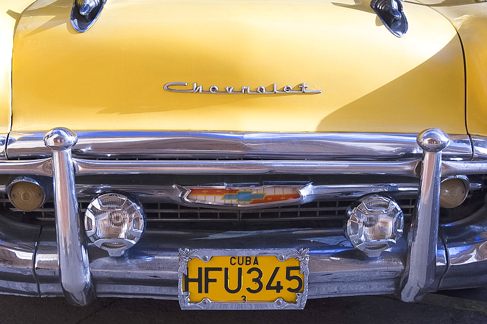 A bright yellow vintage 1950's Chevrolet in Havana, Cuba, West Indies, Central America