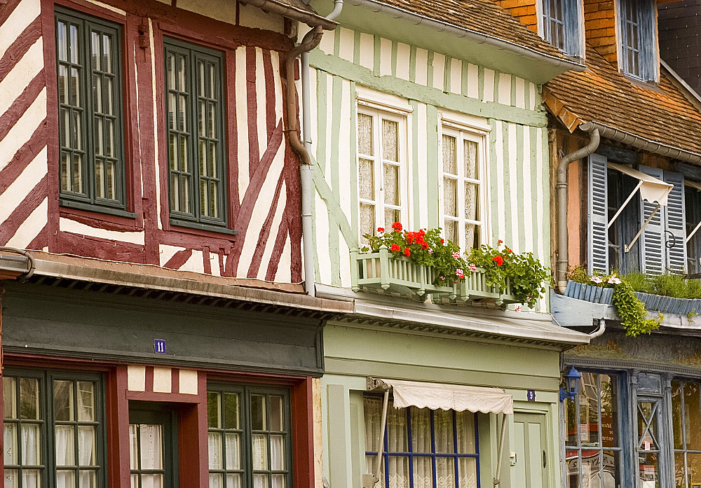 Colourful half timbered houses with geranium filled flower boxes in Beaumont en Auge, Normandy, France, Europe