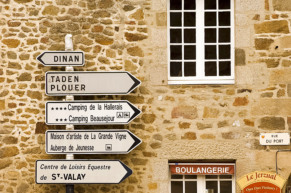 Road signs in front of an old stone house in Port du Dinan, Brittany, France, Europe