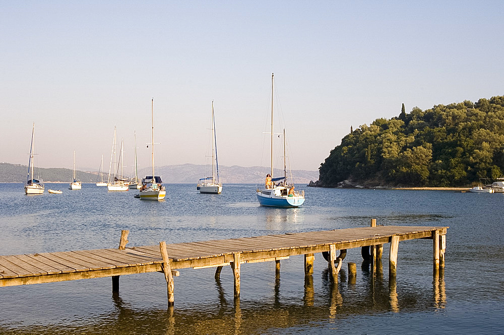 Yachts and a jetty in the harbour in Ayios Stefanos on the northeast coast, Corfu, Ionian Islands, Greek Islands, Greece, Europe