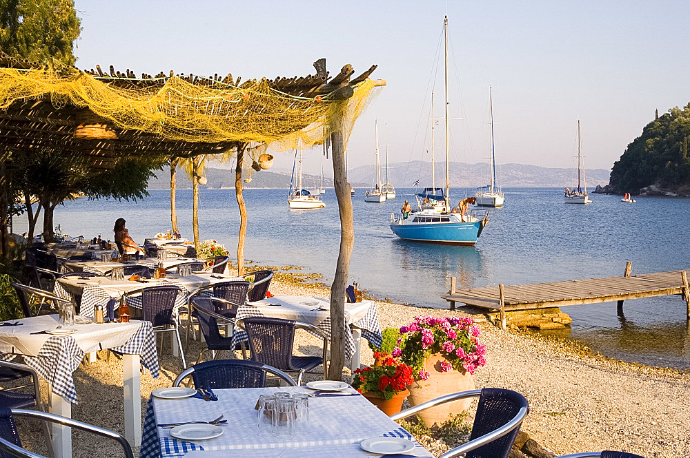 Waterfront taverna and yachts in the harbour at Ayios Stefanos, northeast coast, Corfu, Ionian Islands, Greek Islands, Greece, Europe