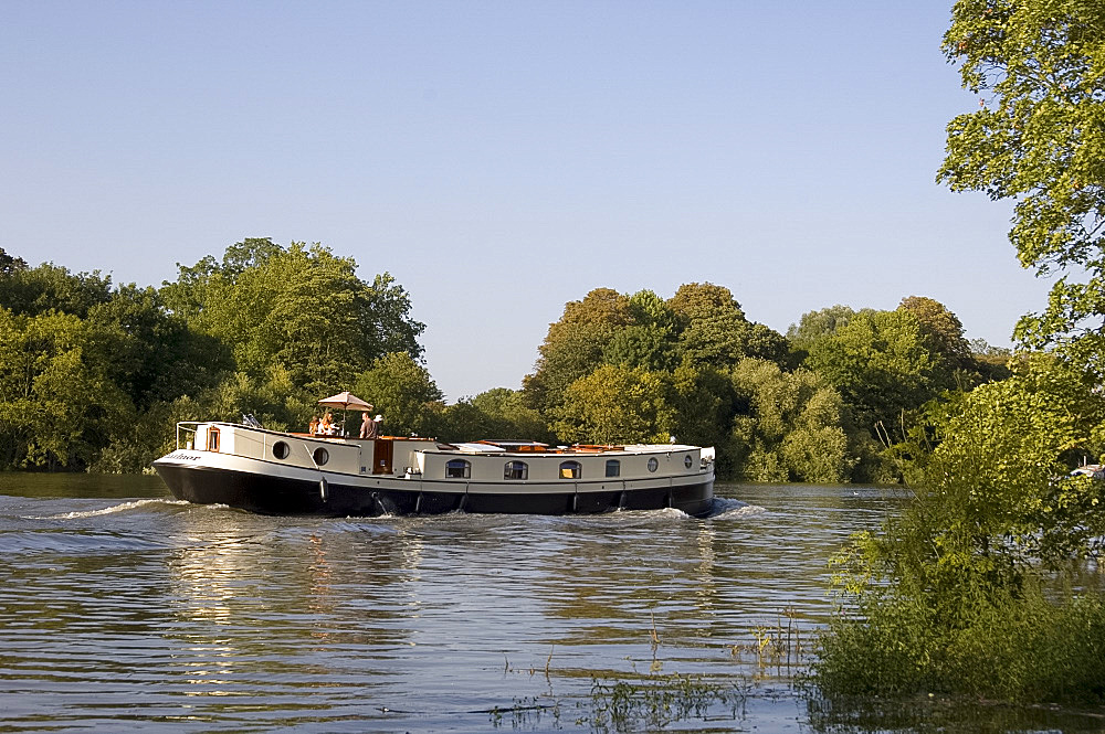 A canal boat on the River Thames during a very high tide at Richmond-upon-Thames, Surrey, England, United Kingdom, Europe