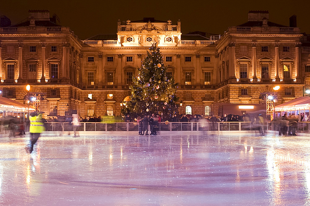 Skaters on the ice rink at Somerset House with a Christmas tree in the background, London, England, United Kingdom, Europe