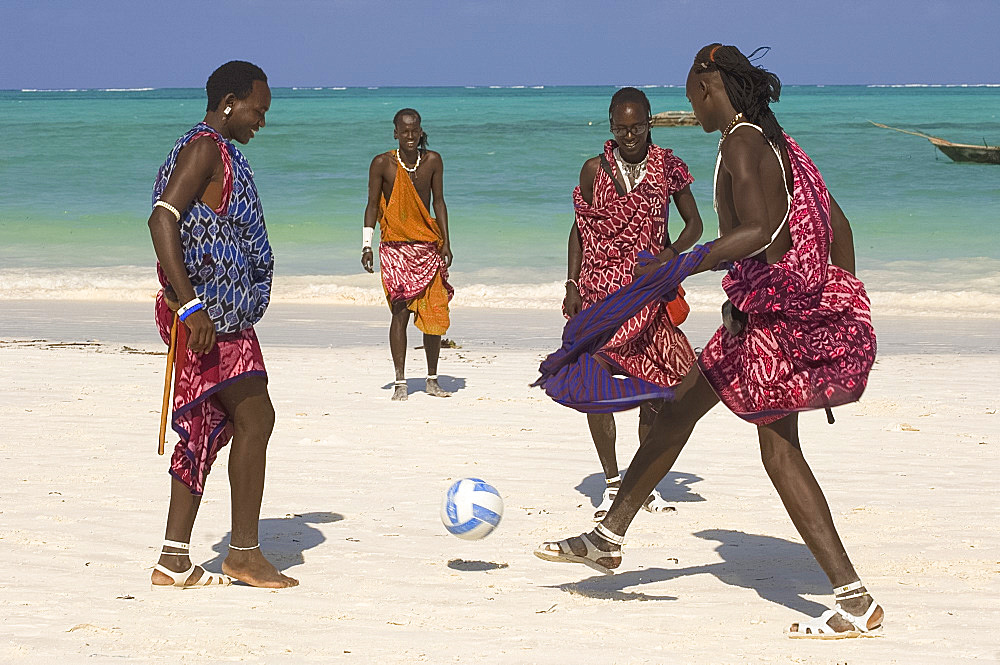 Maasai tribesmen in colourful native dress playing football on the beach, Paje, Zanzibar, Tanzania, East Africa, Africa