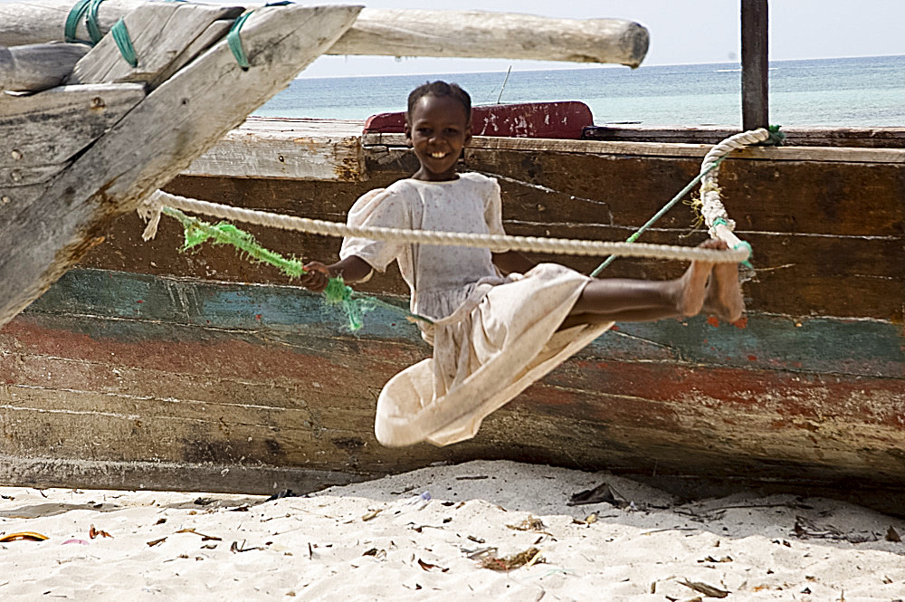 A girl on a makeshift swing on the beach at Nungwi, Zanzibar, Tanzania, East Africa, Africa