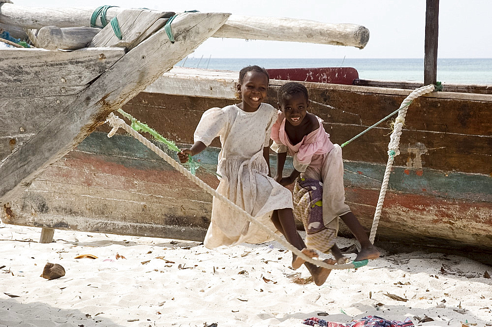 Two little girls on a makeshift swing on the beach at Nungwi, Zanzibar, Tanzania, East Africa, Africa