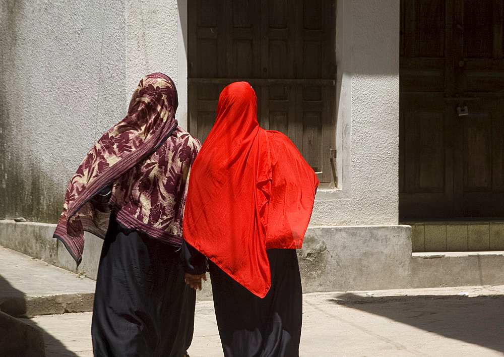 Women wearing colourful headscarves walking in Stone Town, Zanzibar, Tanzania, East Africa, Africa