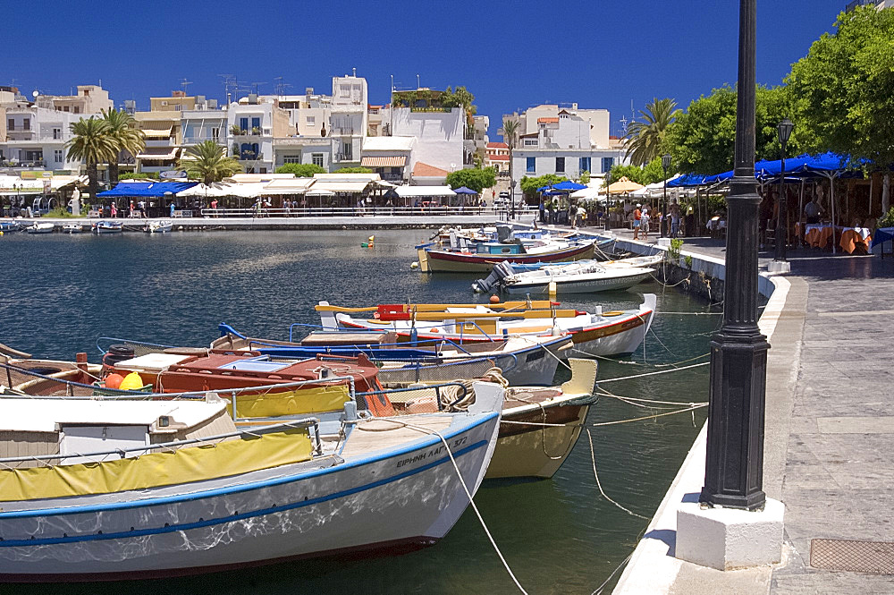 Colourful small fishing boats and tavernas surrounding Lake Voulismeni (the bottomless lake) in Agios Nikolaos (Agios Nikolaus), Crete, Greece, Europe