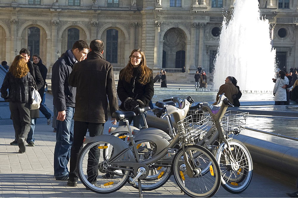 Tourists at the fountains in front of the Louvre with rented Velib bicycles, Paris, France, Europe