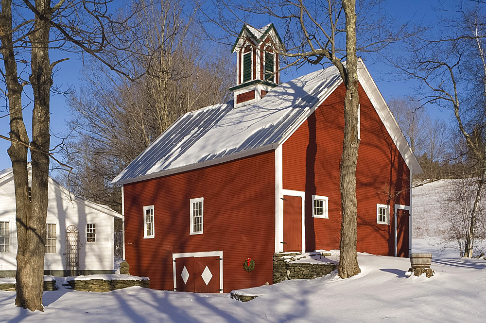 A traditional red painted barn surrounded by snow, Vermont, New England, United States of America, North America