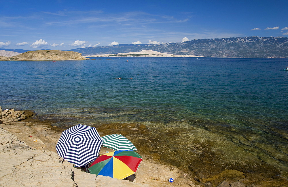 Beach umbrellas by the sea at San Marino, island of Rab, Kvarner region, Croatia, Europe