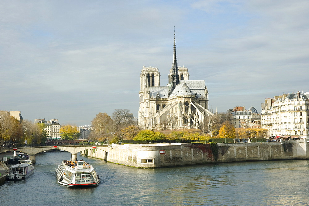 A bateau mouche passing the Ile de La Cite and Notre Dame Cathedral in autumn, Paris, France, Europe