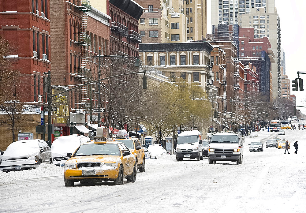 Cars driving through snow on Columbus Avenue in Manhattan after a snowstorm, New York City, New York State, USA