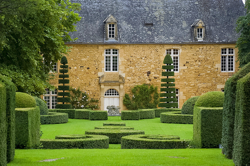 The manor house surrounded by topiary in Les Jardin du Manoir D'Eyrignqac in Salignac, Dordogne, France, Europe