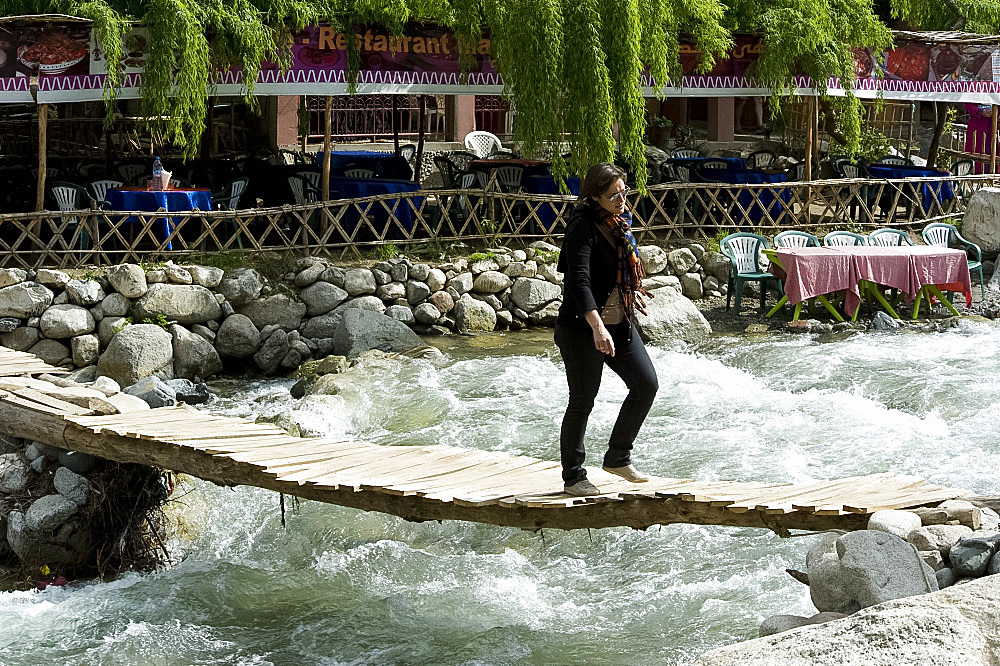 Crossing over a raging river on a precarious wooden slatted bridge in Setti Fatma, Ourika Valley, Morocco, North Africa, Africa