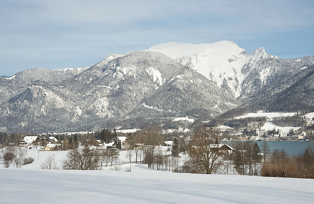 A view of snow covered mountains surrounding St. Wolfgangsee near the town of St. Wolfgang, Austria, Europe