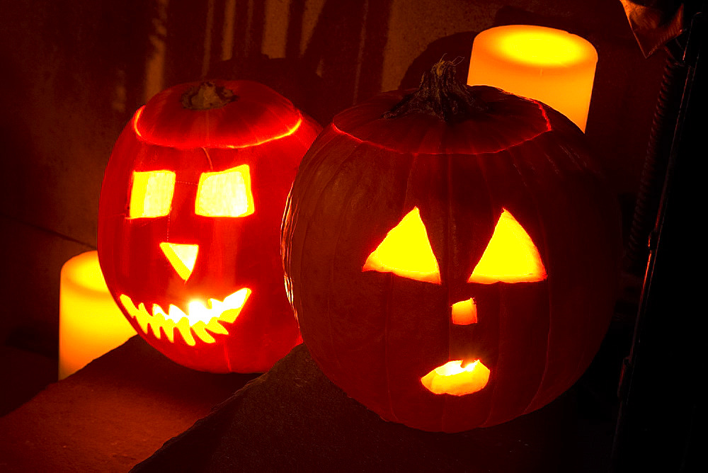 Two jack o'lanterns on the steps of a New York brownstone on Halloween night, Manhattan, New York City, United States of America, North America