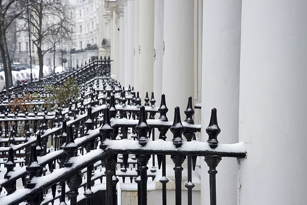 Snow covered iron railings in front of houses in the Notting Hill area of London, England, United Kingdom, Europe