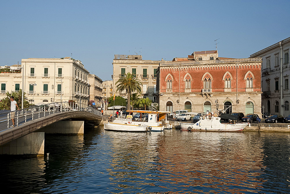 A deep red Venetian style building in the harbour in Ortigia, Syracuse, Sicily, Italy, Mediterranean, Europe