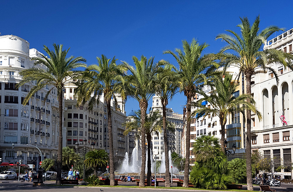 Palm trees, high rise buildings and a fountain in Plaza del Ayuntamiento in Valencia, Valenciana, Spain, Europe