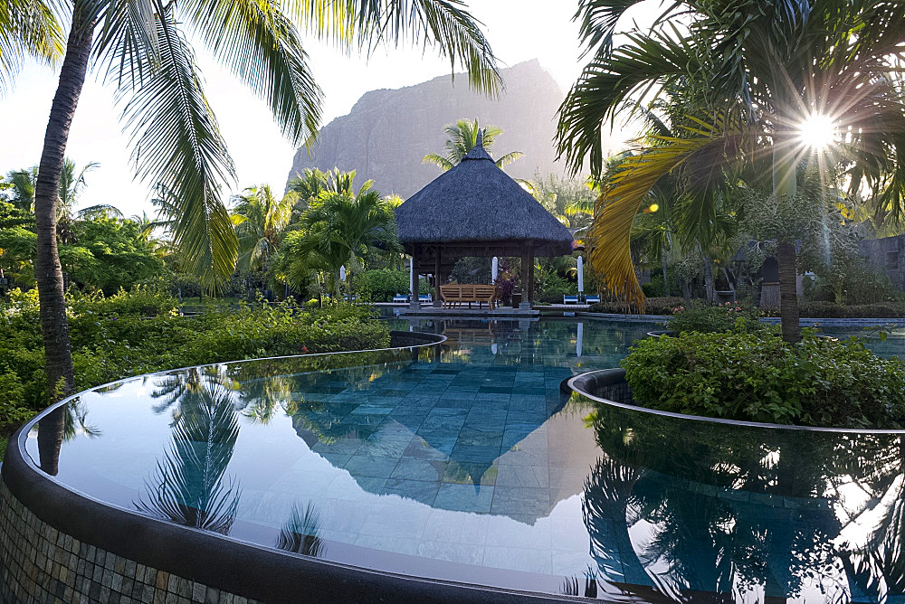 Le Morne Brabant behind an infinity pool at sunrise at the Lux Le Morne Hotel. Le Morne Brabant Peninsula, south west Mauritius, Indian Ocean, Africa