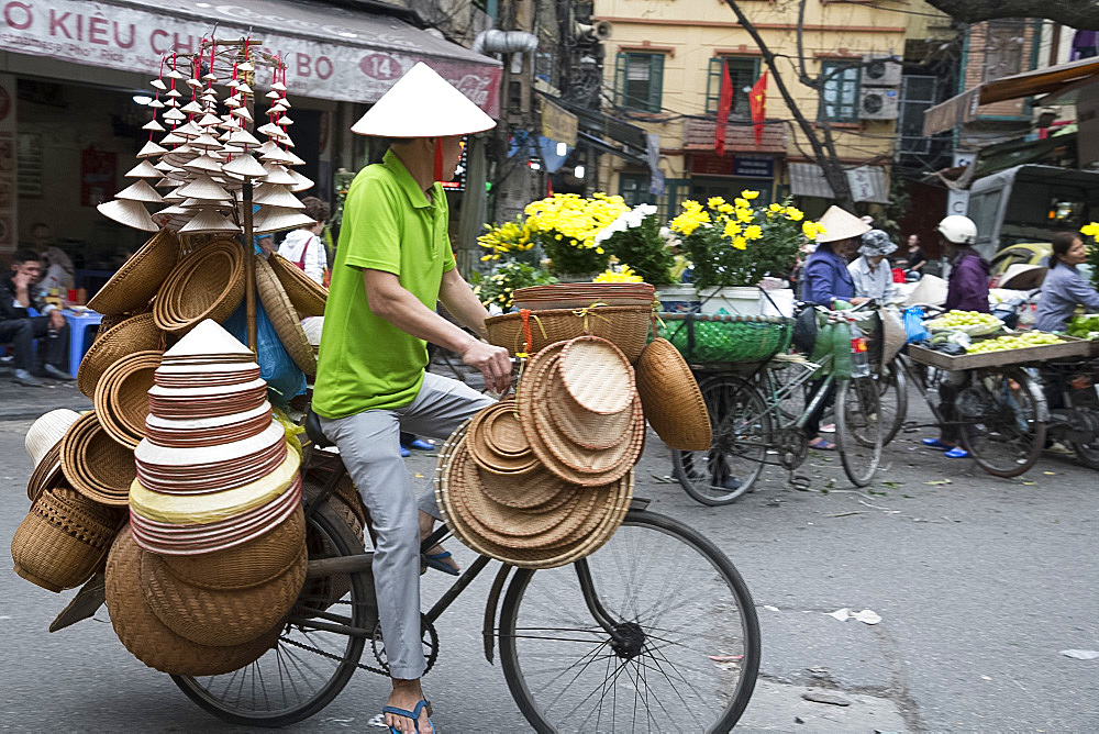 A man selling Vietnamese Conical straw hats and baskets from his bicycle in the Old Quarter, Hanoi, Vietnam, Indochina, Southeast Asia, Asia