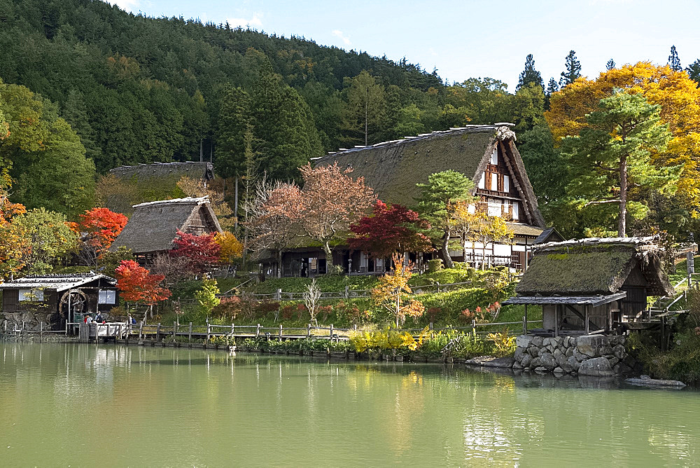 Autumn foliage and traditonal thatched buildings around a lake at Hida Folk Village, Hida No Sato, Takayama, Honshu, Japan, Asia