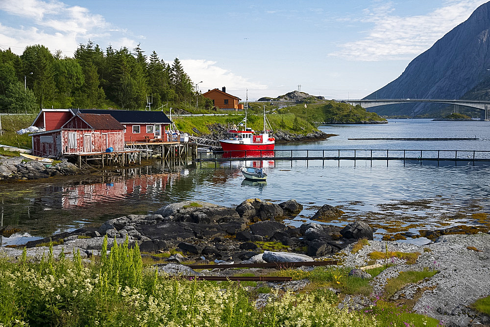 A fishing boat and dock houses near Kakern Bridge, Ramberg, Lofoten Islands, Norway, Europe