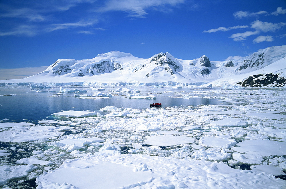 Seascape with ice and snow, and people ice cruising in zodiac, Antarctic Peninsula, Antarctica, Polar Regions