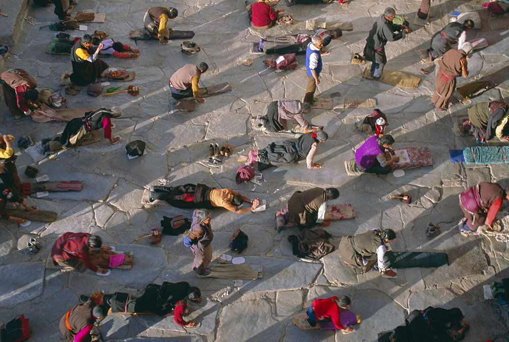 Tibetan Buddhist pilgrims prostrating outside the Jokhang Temple, Lhasa, Tibet, China, Asia