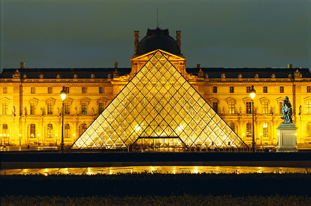 The Louvre and pyramid illuminated at night, Paris, France, Europe