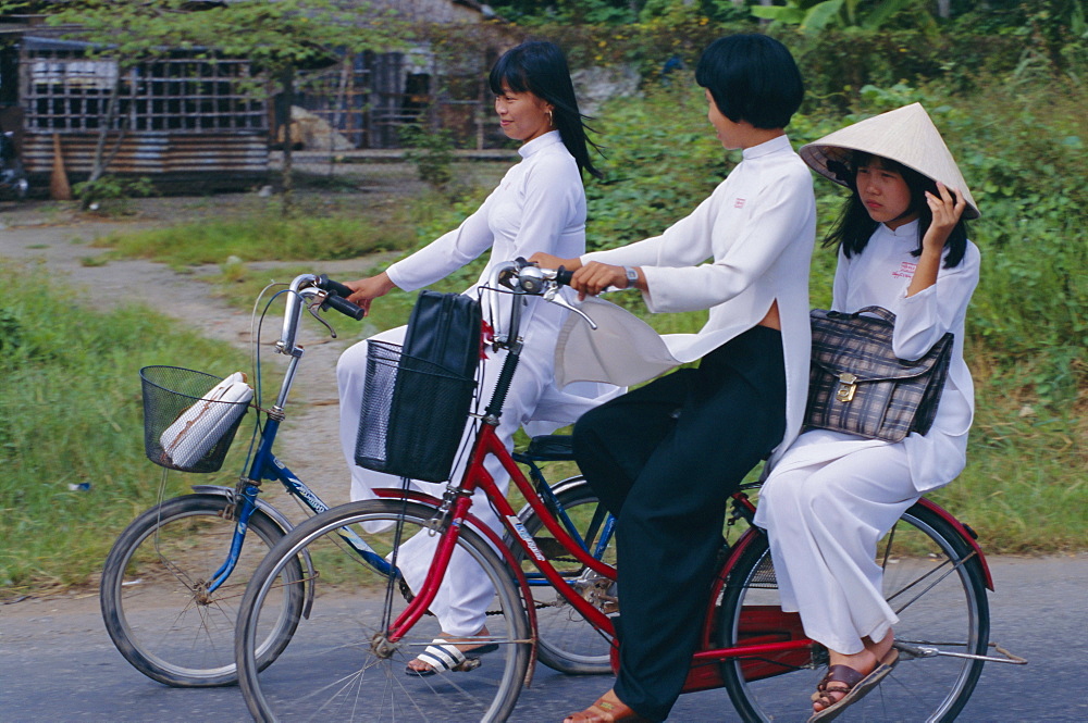 Girls riding bicycles, Ho Chi Minh City (Saigon), Vietnam, Indochina, Asia