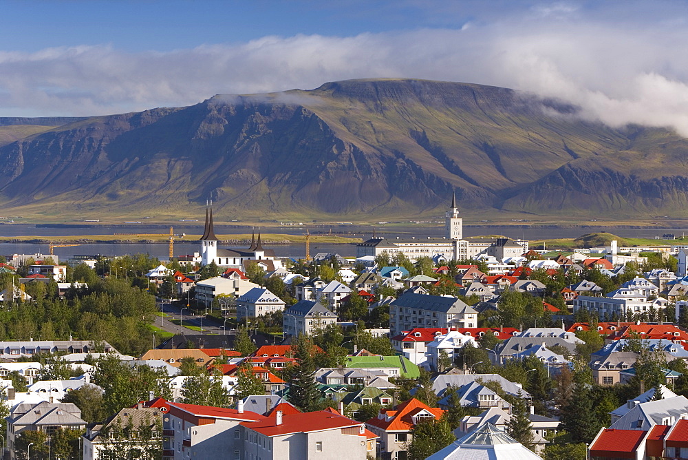 View from the Perlan of colourful houses, commercial buildings, churches and harbour of the city, with mountains beyond, Reykjavik, Iceland, Polar Regions