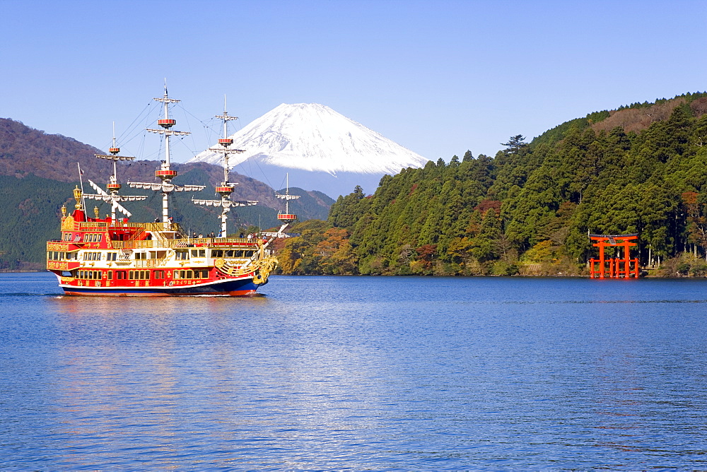 Tourist pleasure boat on lake Ashino-ko with the red torii gates of Hakone-jinja rising from the lake and snow capped Mount Fuji beyond, Fuji-Hakone-Izu National Park, Hakone, Central Honshu (Chubu), Japan, Asia