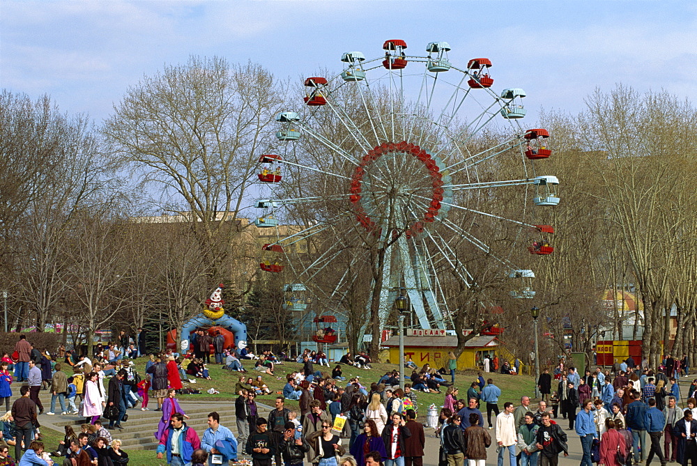 Crowds at a funfair with a big wheel during Earth Day Festival in Gorky Park in Moscow, Russia, Europe