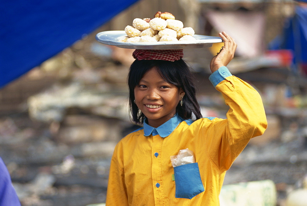 Young girl carrying plate on head, Phnom Penh, Cambodia, Indochina, Southeast Asia, Asia