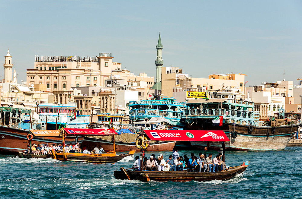 Abra water taxis passing dhows along Dubai Creek, Dubai, United Arab Emirates, Middle East