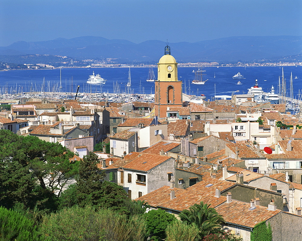 The town skyline with ships in the bay in the background, St. Tropez, France, Europe