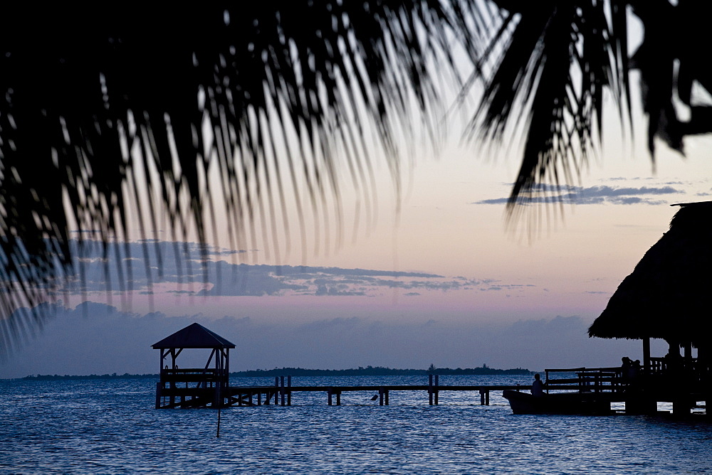 People in beach bar near the Moorings at sunset, Placencia, Belize, Central America